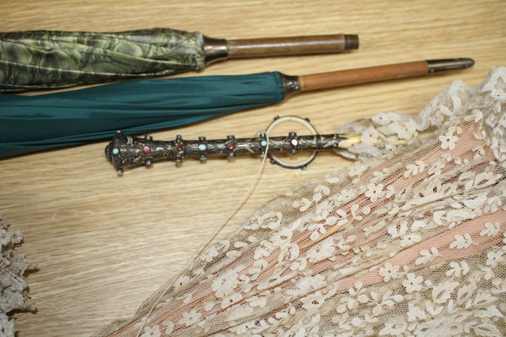 A group of assorted Victorian and later parasols including one with jewelled silver and ivory folding handle